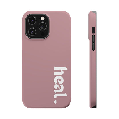 A person wearing a red sweater holding a pink iPhone case with the word 'heal' printed on it.