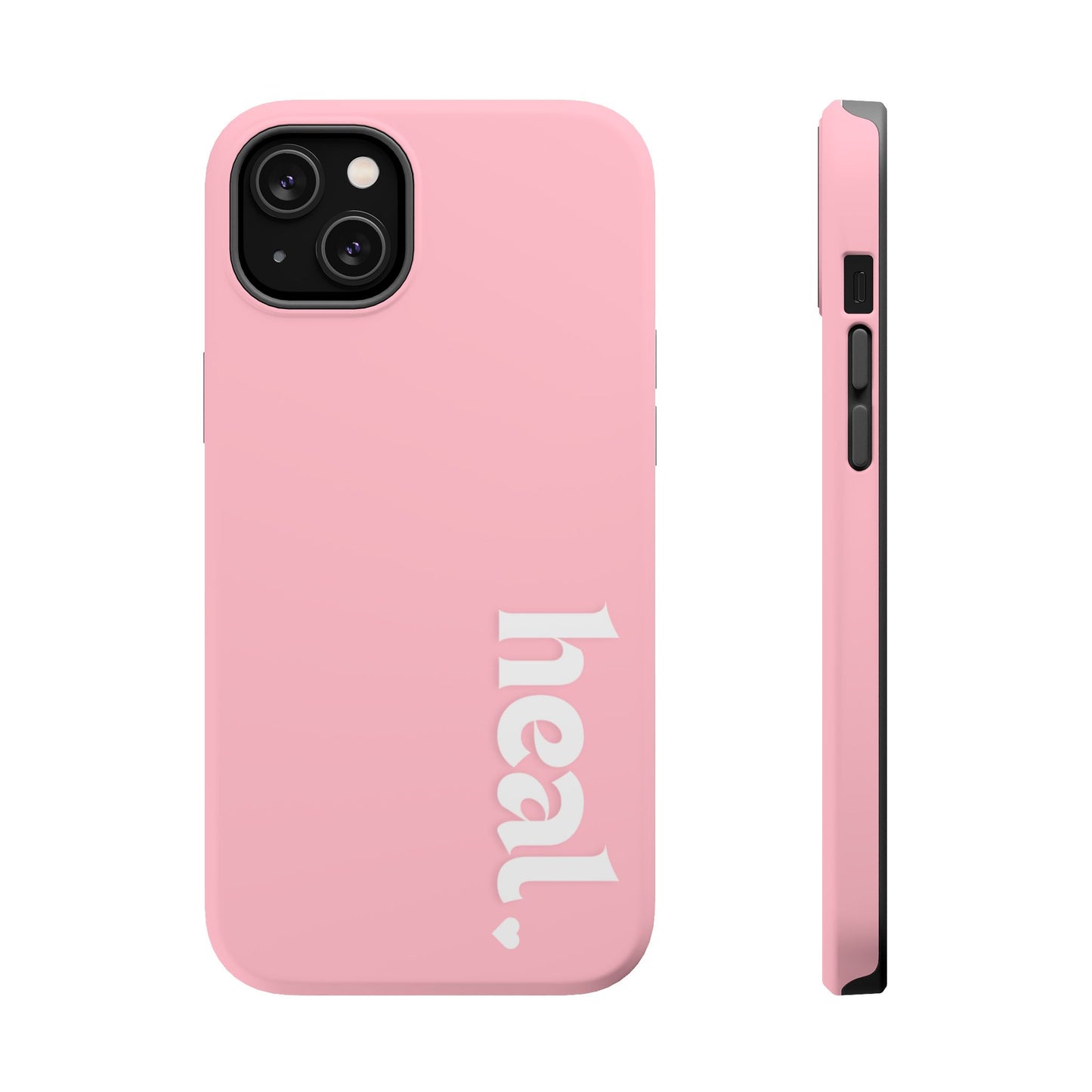 A pink iPhone case with the word 'heal' written on it, displayed on a table with candles and flowers in the background.